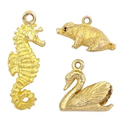 Three 9ct gold pendant / charms including sitting pig, seahorse and swan