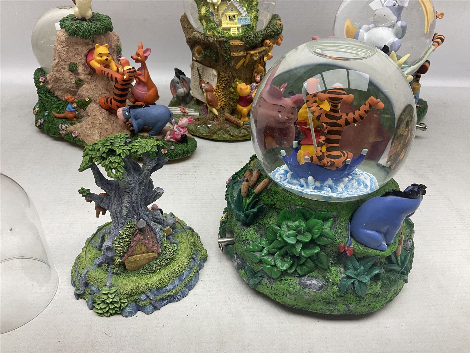Five Disney Winnie The Pooh snow globes to include The Rain Rain Rain Came Down Down Down, Eeyore Pulling Cart, Owl's House, Rumbly in My Tumbly and Stuck In Rabbit's House, together with figure group with dome, five with boxes (6)