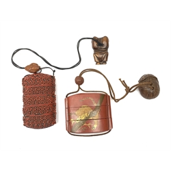 A Japanese cinnabar lacquer inro, of five sectional form, the whole with carved foliate detail, with wooden ojime, and carved hardwood Netsuke modelled as one of the Lucky Gods, Fukurokuju standing upon his hands, inro H8.5cm, together with a Japanese lacquer inro, of three sectional form, detailed with a tiger and bamboo branches, with ojime, and wooden netsuke modelled as a basket with animals within, inro H6cm.