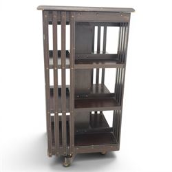 20th century ebonised revolving bookcase, square top with chamfered edges, over a three tier with four sections per tier,  revolving base on castors 