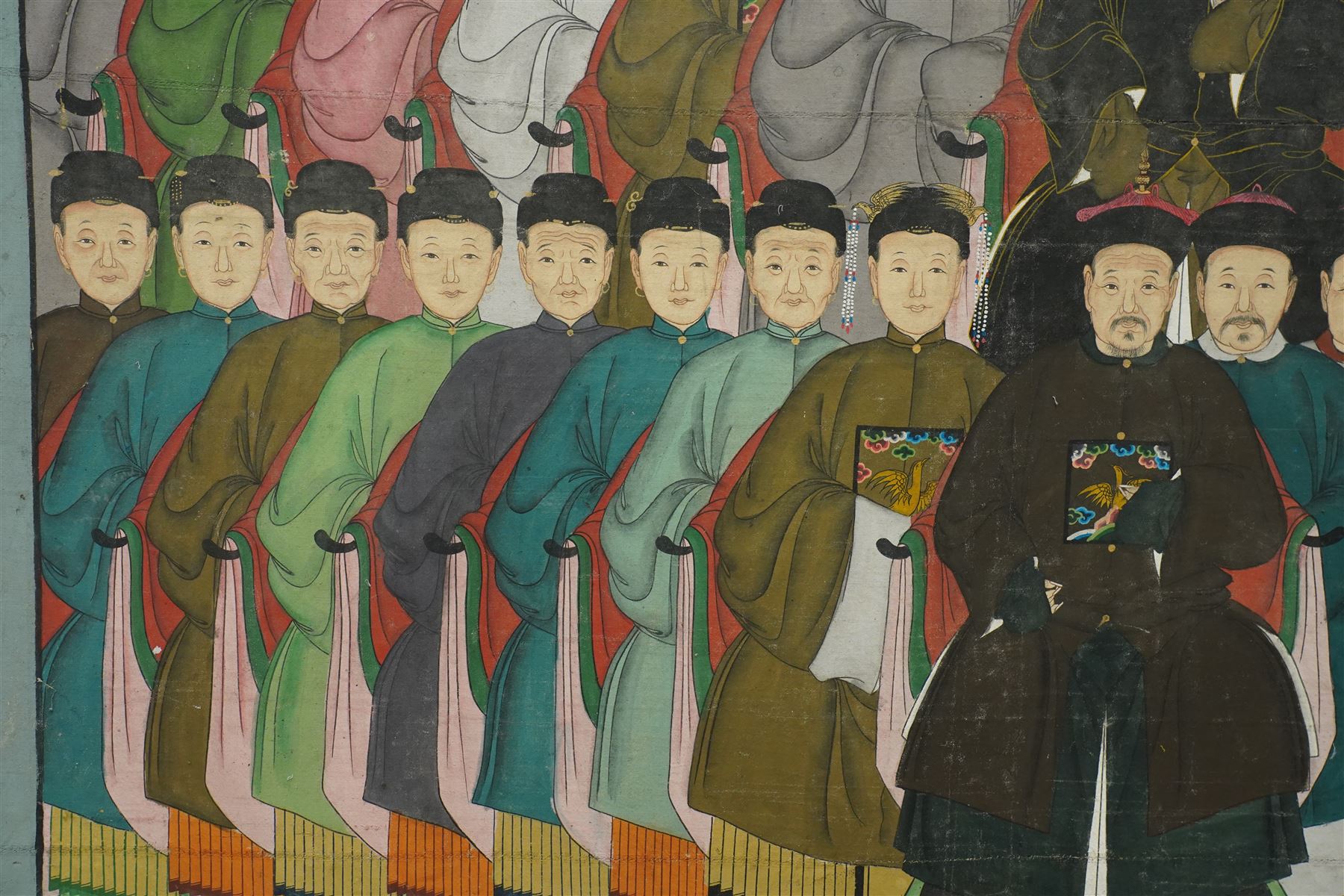 Large and impressive Chinese ancestral portrait, late Qing dynasty, gouache on stitched canvas with gilded highlights, showing thirty-eight sitters across four registers, the principal ancestors depicted before an altar table holding various ritual items, each in official dress and many wearing Golden Pheasant (Second-rank) and Silver Pheasant (Fifth-rank) Mandarin squares or 'buzi', overall 190cm x 131cm 