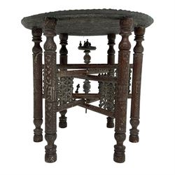Anglo-Indian Benares table, circular pierced copper top decorated with trailing foliage, on folding hardwood stand carved with scrolls and incised decoration