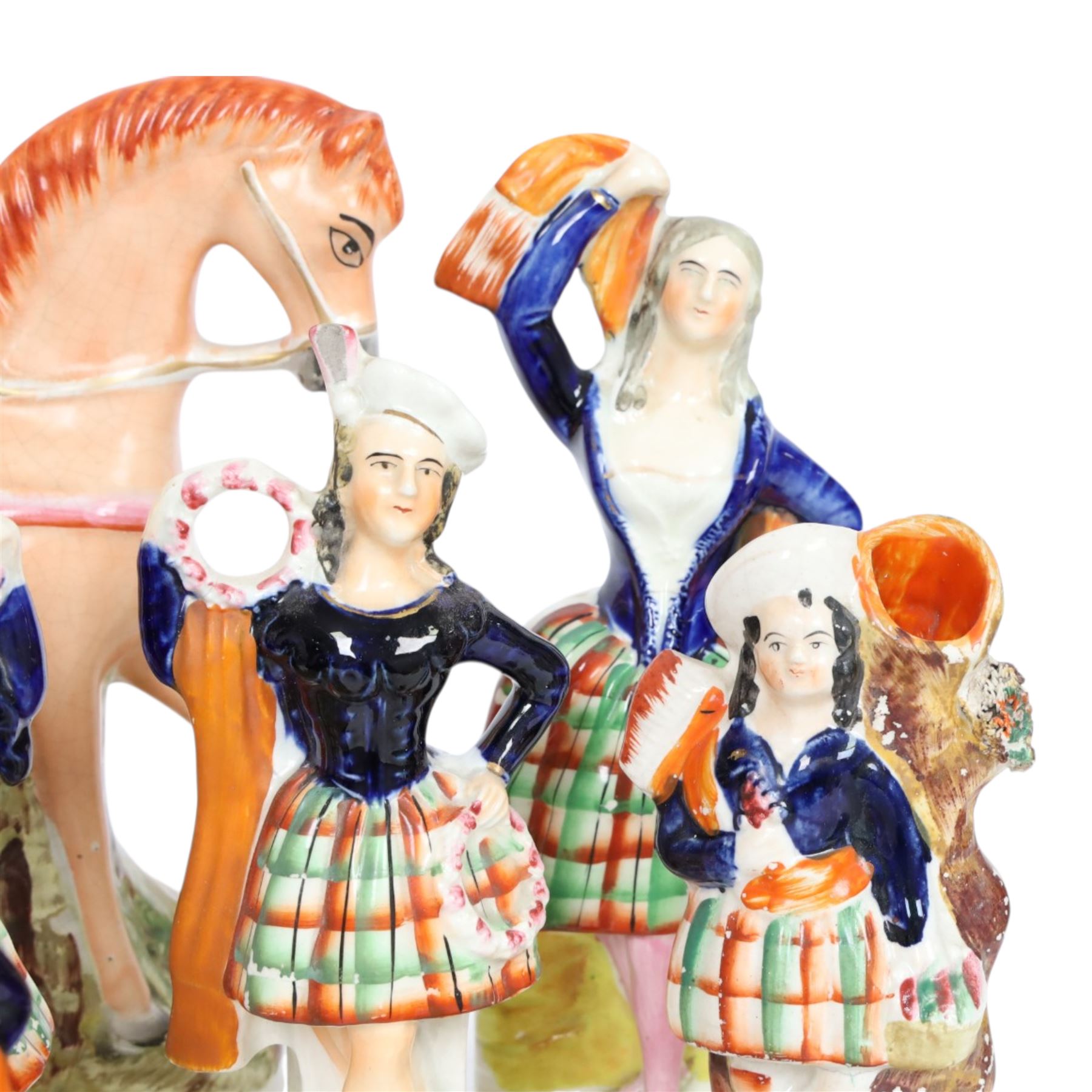 Group of Staffordshire figures, mostly Highland examples, to include figure with bagpipes upon horseback, figure group of Highland Mary and Byron, two figure groups depicting pair of dancers holding flag aloft, two pairs of recumbent sheep, one pair with fags, largest example H30cm