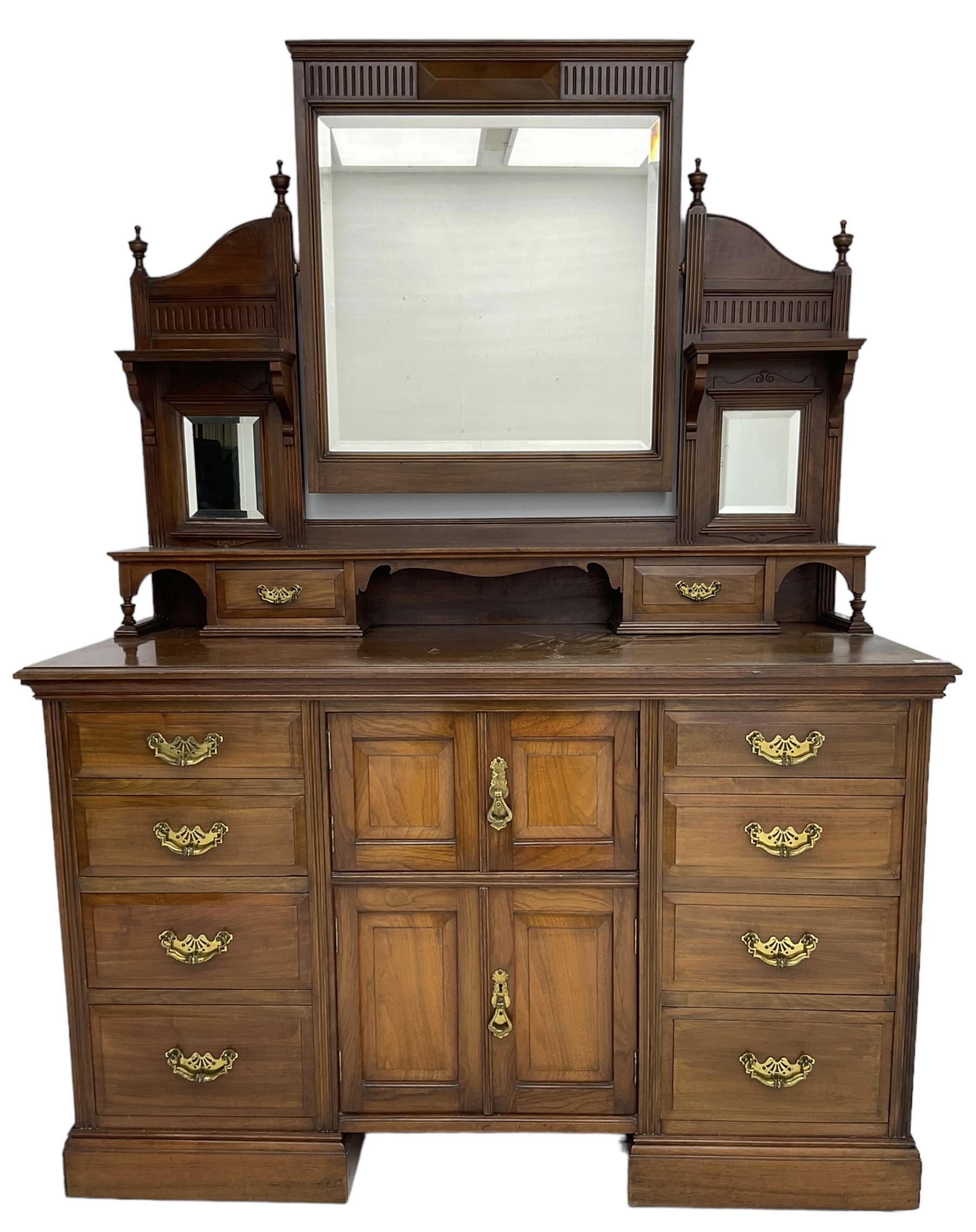 Edwardian mahogany dressing chest, raised triple mirror back with bevelled plates and fluted decoration over two trinket drawers, the base fitted with two central cupboards flanked by four graduating drawers to each side