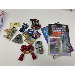 Four 1980sTransformer G1 - Optimus Prime 1984; DinoBot Sludge (Diplodocus) 1984; Cyclonus 1986; and Runamuck 1986; with paperwork; seven Bandai Robo Machines Robots/Transformers; almost fully stocked Panini Sticker album; two annuals; three comics; two posters; and Ladybird story book