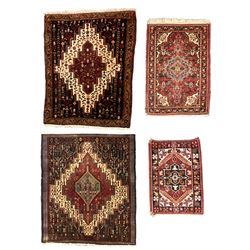 Small Hamadan dark indigo ground rug, central ivory and maroon lozenge with geometric decoration, guarded border with repeating stylised plant motifs, together with three others (4)