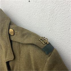 WW2 British female ATS Sergeant's service uniform grouping, consisting of four pocket female pattern service dress tunic with brass ATS shoulder titles and general service buttons; cloth lined interior with the original printed size label dated 1942; the matching khaki service dress skirt; and Greatcoat with size label dated 1945; together with army knitted sleeveless V-neck jumper; WRAC tunic, skirt and overcoat; full length cream and gold thread military evening dress by Hilliers Couture; and four webbing belts