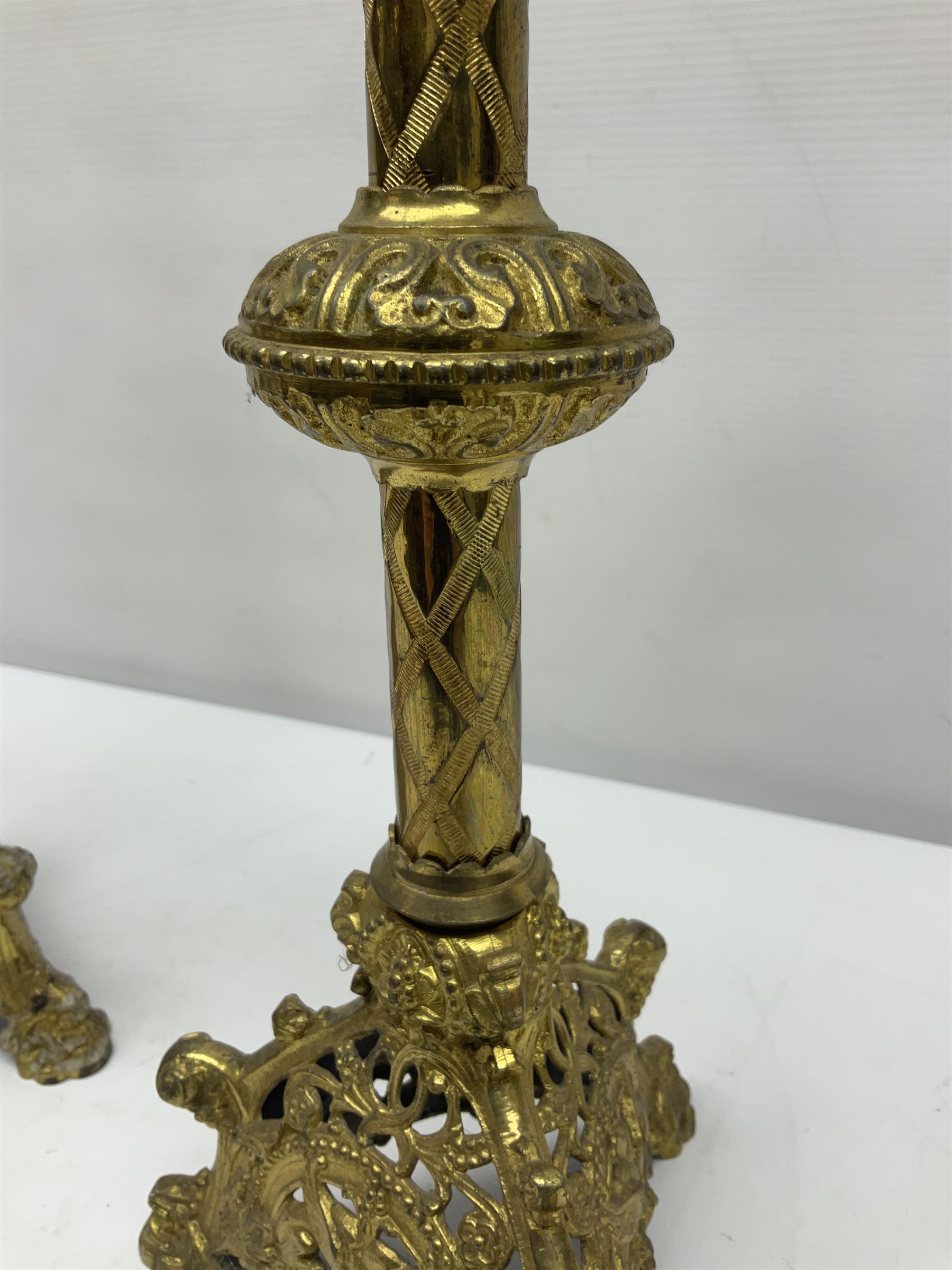 Pair of gilt metal pricket candlesticks, with applied decoration on knopt stems and triform bases, H47cm