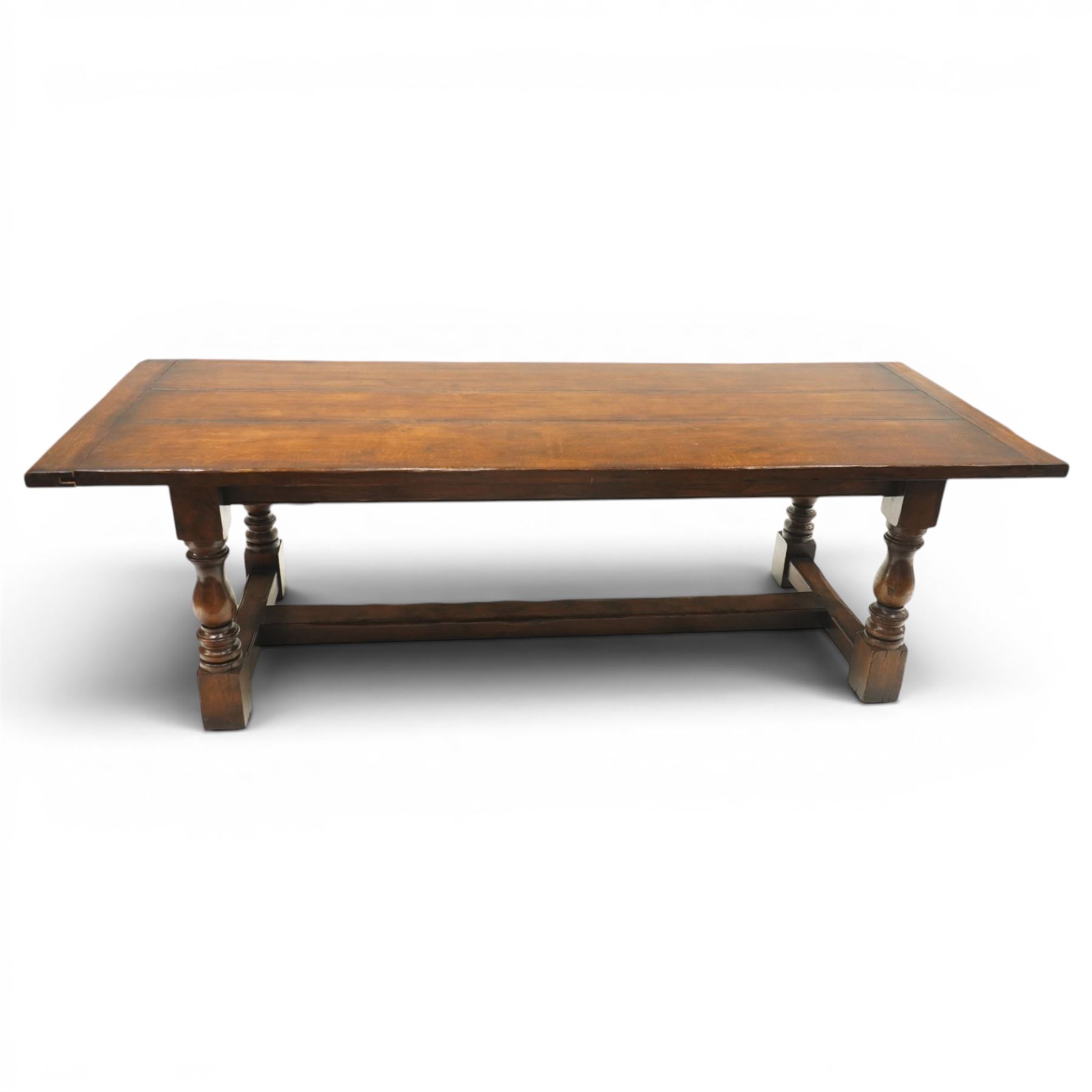 17th century design 8ft dark oak refectory dining table, the rectangular top raised on four turned baluster supports united by H-stretcher