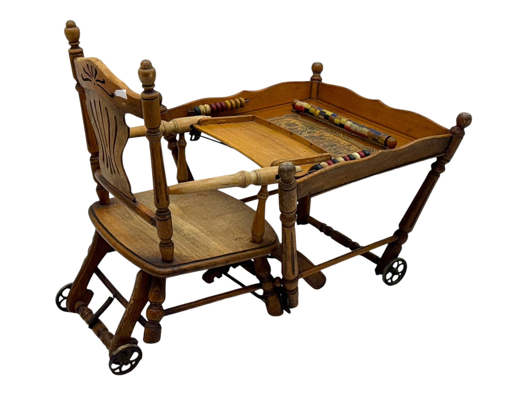 Late 19th century American oak child's metamorphic high chair and play table, carved spindle backrest with pierced splat, detachable tray with abacus and hand painted pastoral decoration, on turned supports with metal wheels