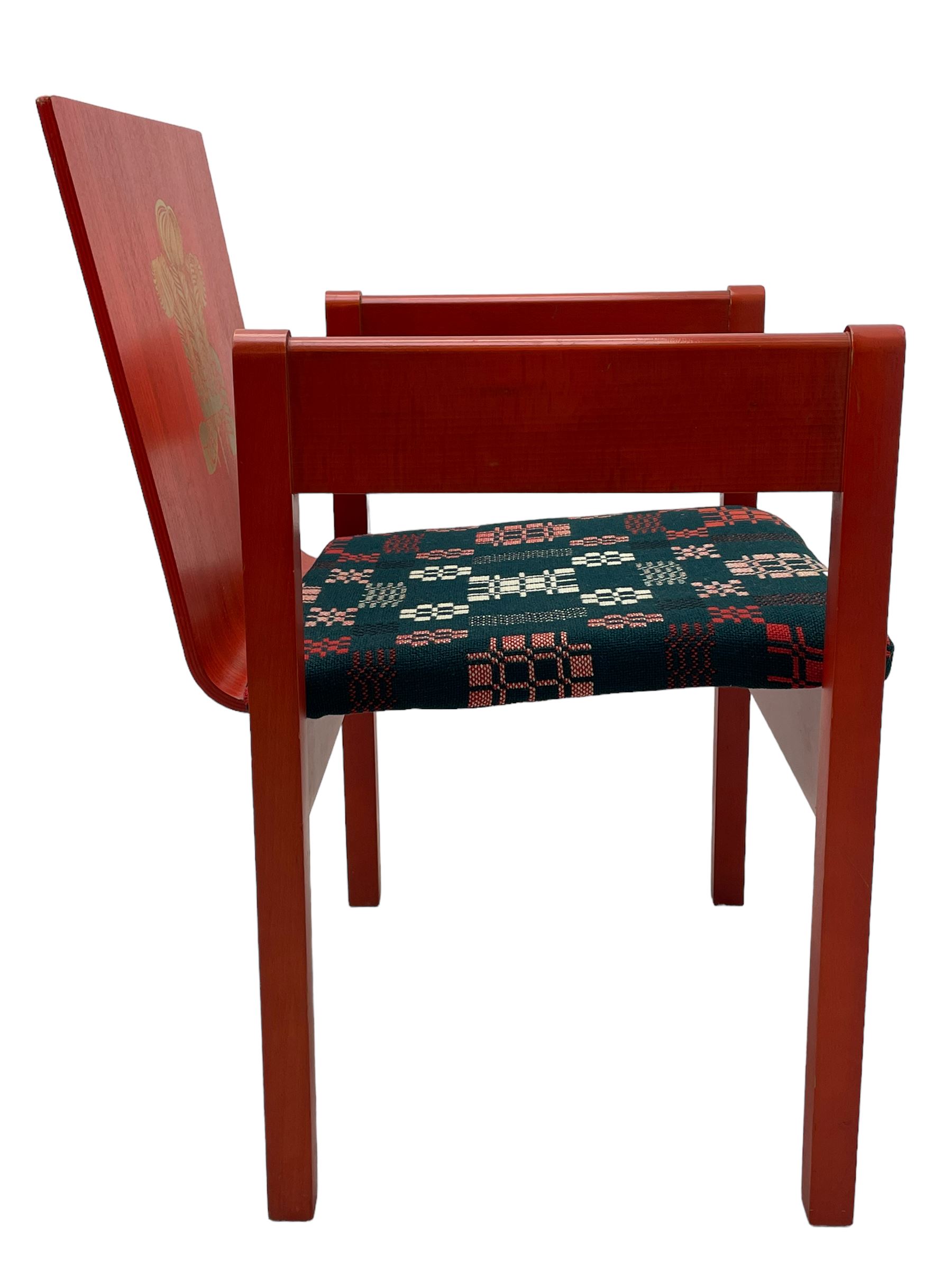 Prince Charles Investiture Chair - designed by Lord Snowdon, manufactured by Remploy, 1969, red finish and decorated with the Prince of Wales's feathers and moto 'Ich Dien' in gilt, later upholstered seat in 1950s design Welsh blanket weave fabric 