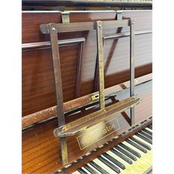 Waddington - Edwardian mahogany upright piano, rectangular top with panelled front, rounded key cover, makers name on fallboard, raised on bracket supports with castors