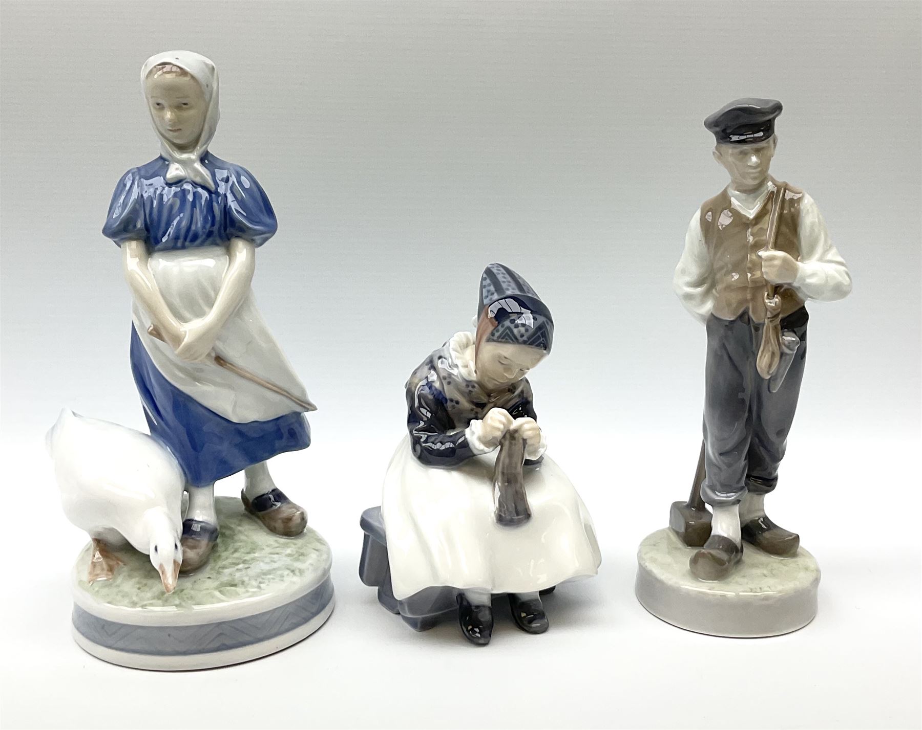 Three  Royal Copenhagen figures, girl knitting 1314, girl standing with a goose 527 and man in traditional Dutch clothing with hammer 620