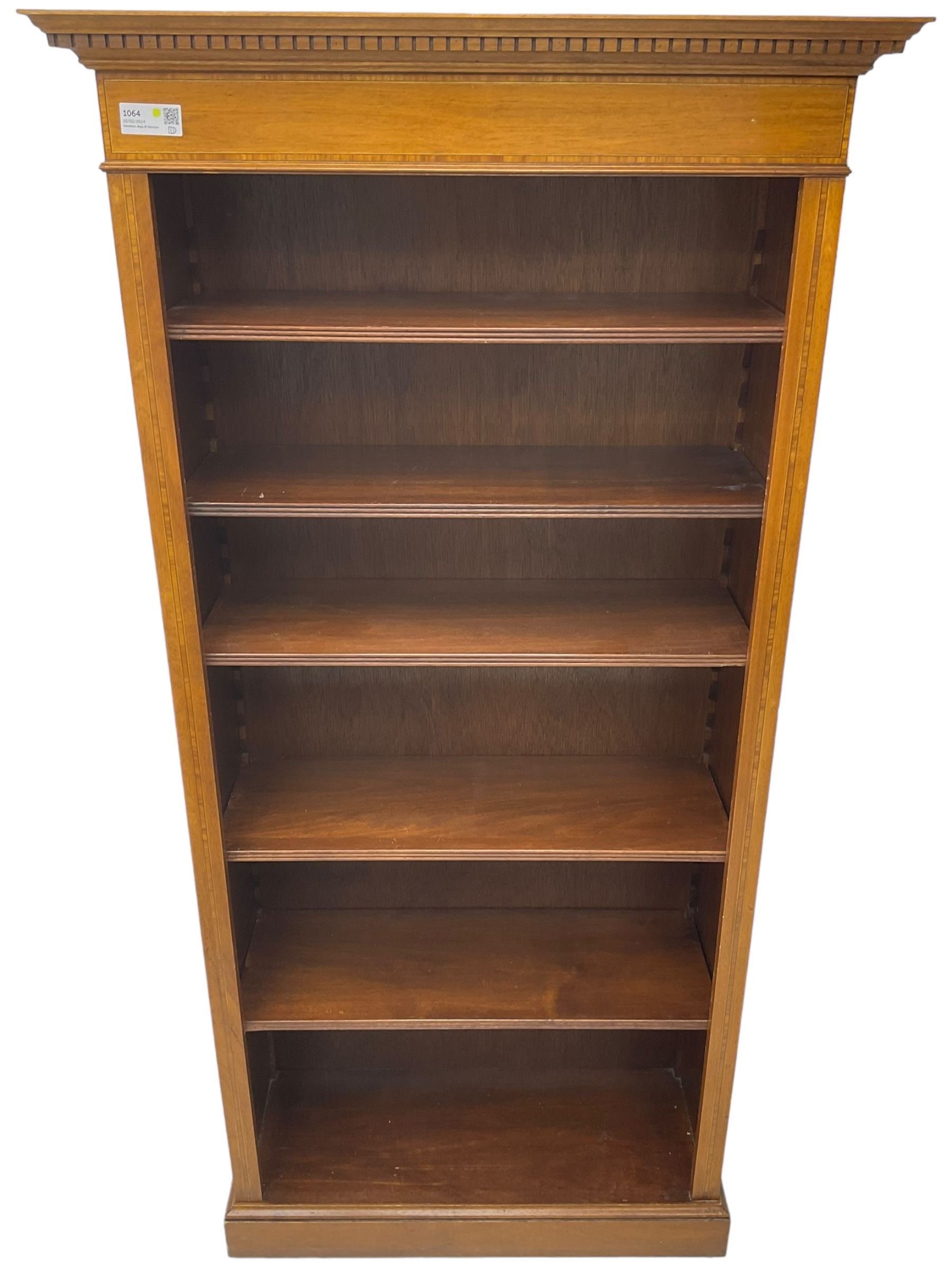 Edwardian inlaid mahogany open bookcase, projecting dentil cornice over crossbanded frieze, fitted with four adjustable shelves with reeded facias, on skirted base