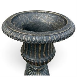 Pair of Neoclassical design black and gilt painted cast iron garden urns of campana form, with egg-and-dart rims and fluted bodies, on knopped stems, fluted socles and stepped square plinth bases