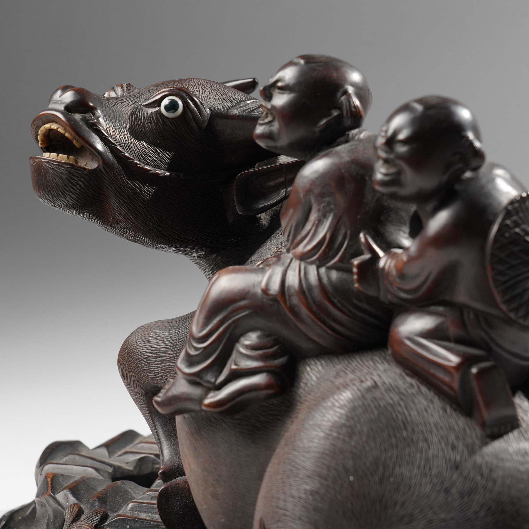 Early 20th century Chinese carved hardwood figural group of two boys on the back of a water buffalo on wooden stand W37cm