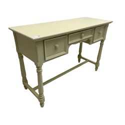 Cream finish side or dressing table, moulded rectangular top over three drawers, on turned supports united by H-shaped stretchers