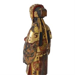 Pair of Asian carved wooden lacquered figures, in ceremonial dress, possibly wedding attire, highlighted throughout in gilt, H22cm