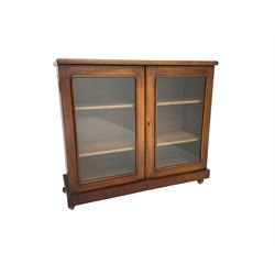 Victorian bookcase, rectangular top over two glazed doors enclosing two shelves, on skirted base
