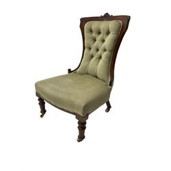 Victorian walnut nursing chair, the cresting rail carved with central floral motif, upholstered in buttoned fabric, turned supports on castors 