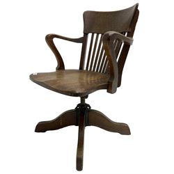 Early 20th century swivel office desk chair, shaped bar back over vertical rails, dished seat, on four splayed supports