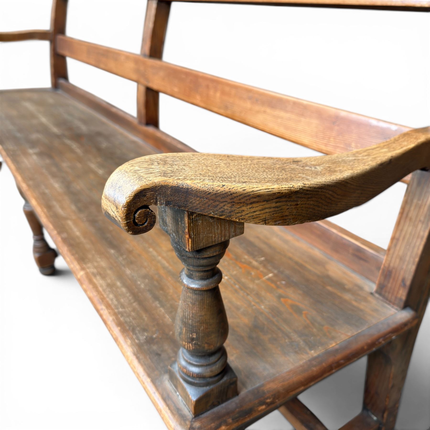 Early 20th century pine and oak bench seat, stained pine rail back frame with shaped oak arms
