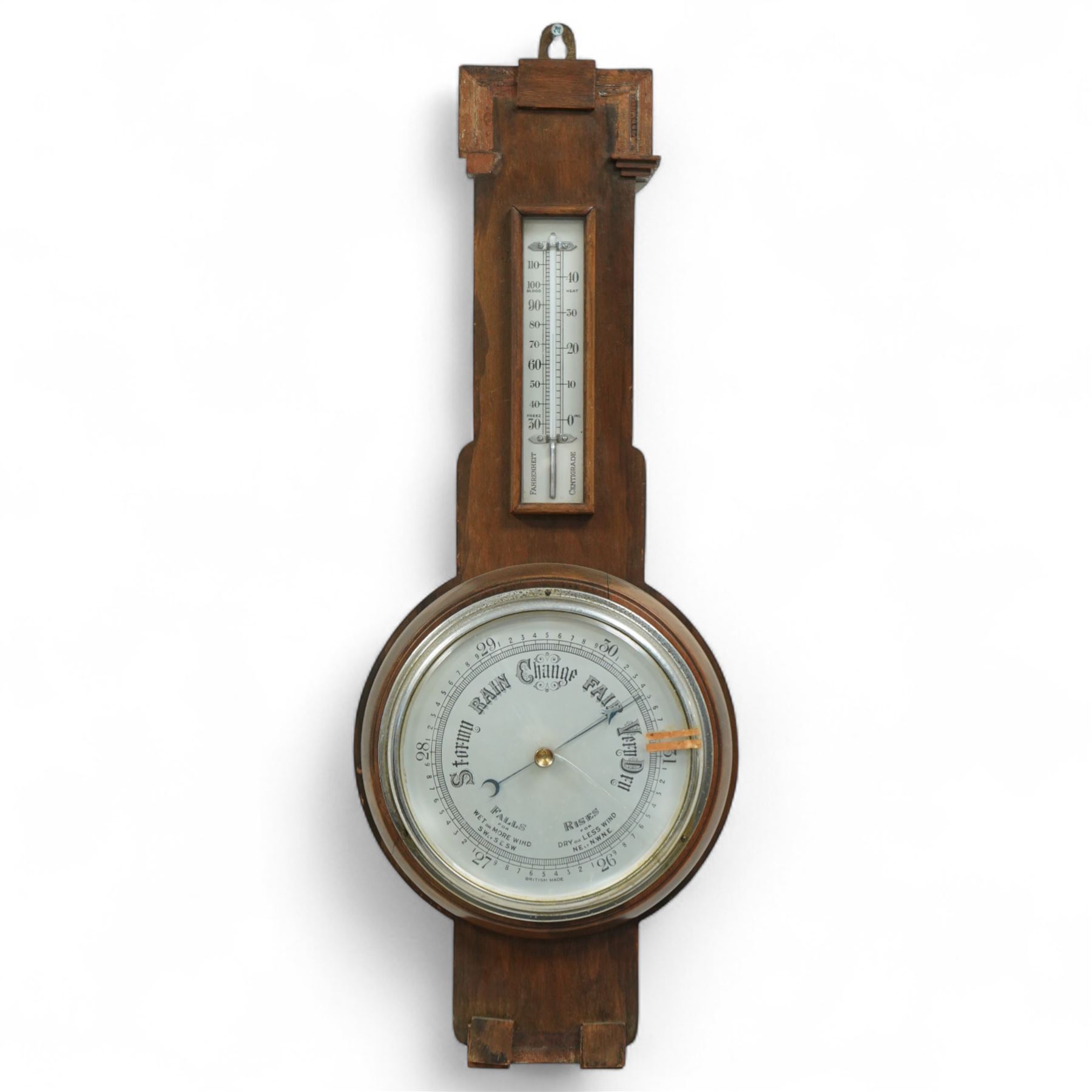 An English 20th century aneroid barometer with a slivered dial and surface mounted mercury thermometer.