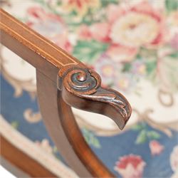 Edwardian inlaid mahogany elbow chair, satinwood banded cresting rail decorated with acanthus leaf carving, open pierced and interlaced back inlaid with curled foliage, floral pattern fabric upholstered seat, on square tapering supports with compressed spade feet