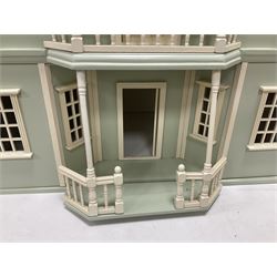 Wooden double-fronted, three-storey dolls house, with pale green stucco finish and simulated tile roof, the central recessed front door with balustraded balcony above, single hinged front opening to reveal a five fully decorated rooms, together with a quantity of dolls house furniture and accessories W64cm, H75cm, D36cm