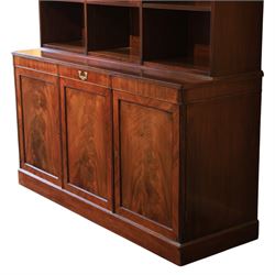 Early 20th century mahogany open bookcase, with reeded upright divisions and adjustable shelves, over a cupboard base fitted with three frieze drawers and three panelled doors, on plinth base