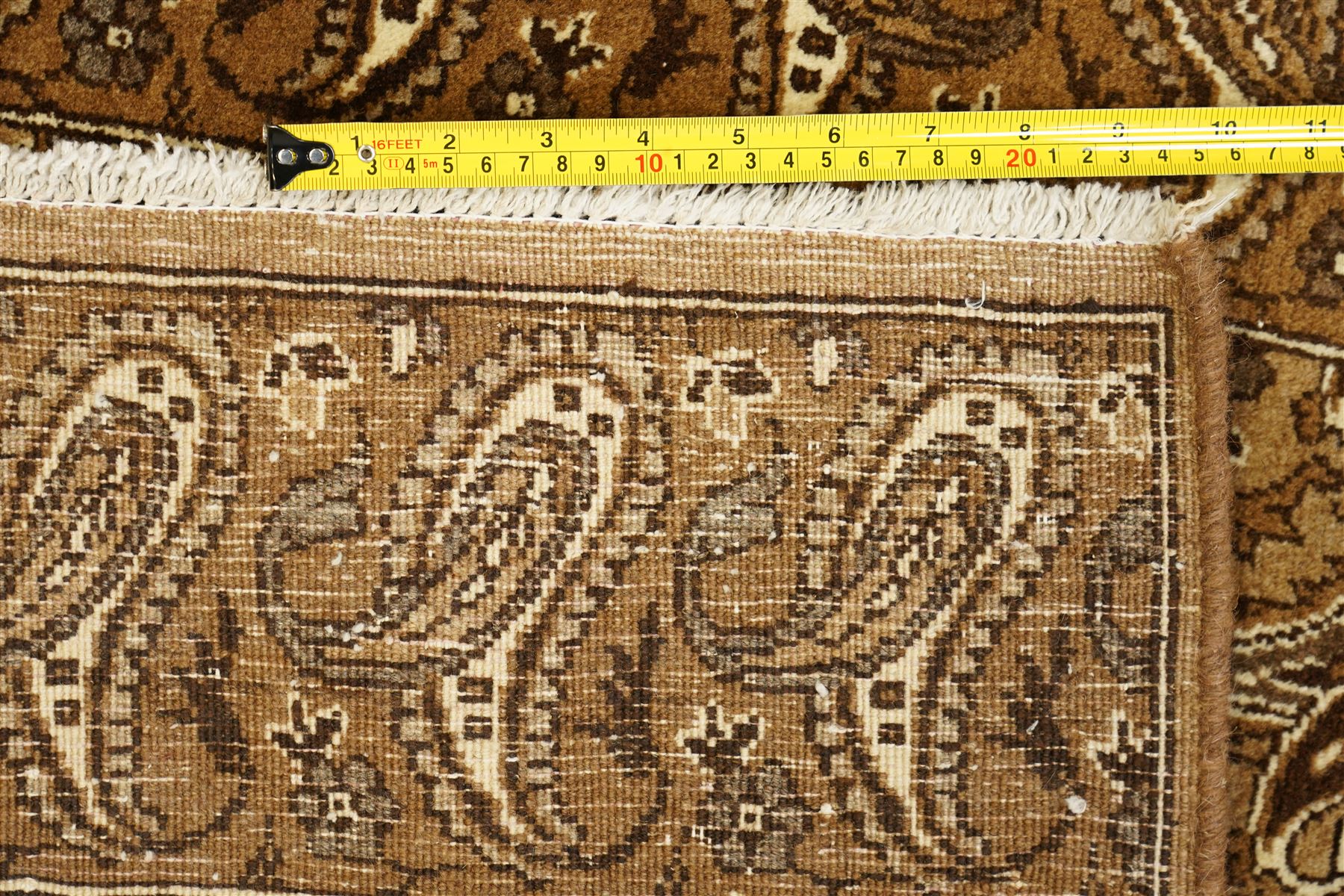 North West Persian Tabriz hand-knotted carpet, field with an all-over repeating boteh design arranged in rows, enclosed by a complimentary border flanked by guard stripes, in a palette of camel, beige and brown tones, with cotton fringe ends 