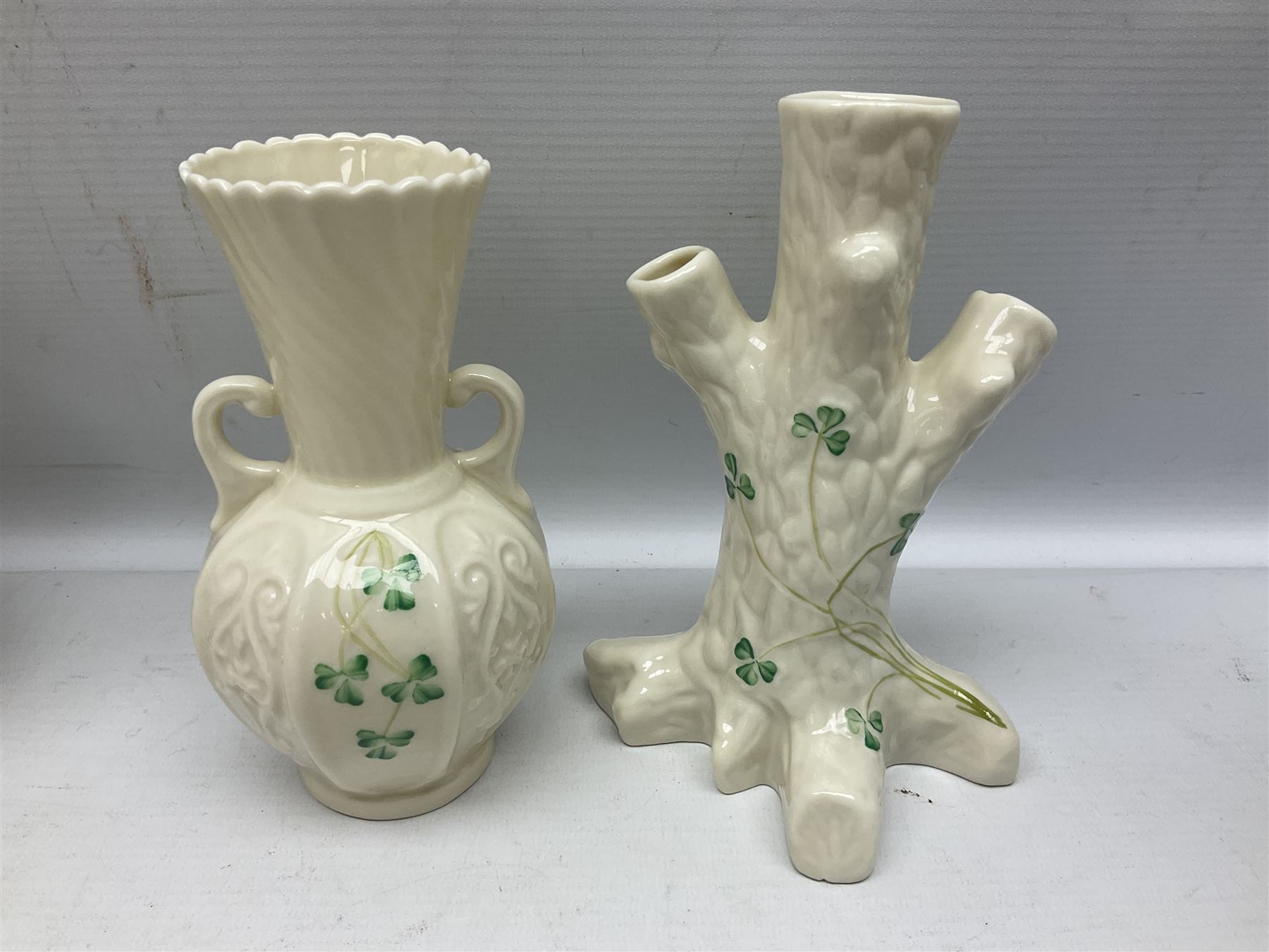 Five late 19th/early 20th century and later Belleek vases, comprising pair of Lotus Blossom examples, shamrock tree trunk vase, twin handled shamrock vase and a baluster form vase decorated with applied roses, all with printed marks beneath, tallest H16cm