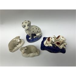 A Victorian Staffordshire figure group pen holder modelled as a Spaniel and puppies, upon a cobalt blue base heightened with gilt, H7cm L12cm, together with a Victorian Staffordshire figure of a Dalmatian, H13cm, and a pair of Victorian Staffordshire sheep. 