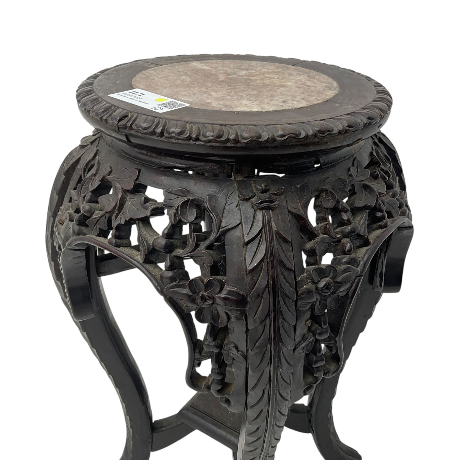 Late 19th century Chinese hardwood pedestal stand, circular top with inset marble panel, carved apron with openwork foliate and floral motifs, raised on cabriole supports with stylised claw and ball feet united by square undertier
