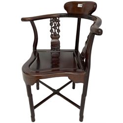 Chinese carved hardwood corner chair, outswept arms over pierced and carved floral splats, raised on shaped cylindrical supports united by X-stretcher