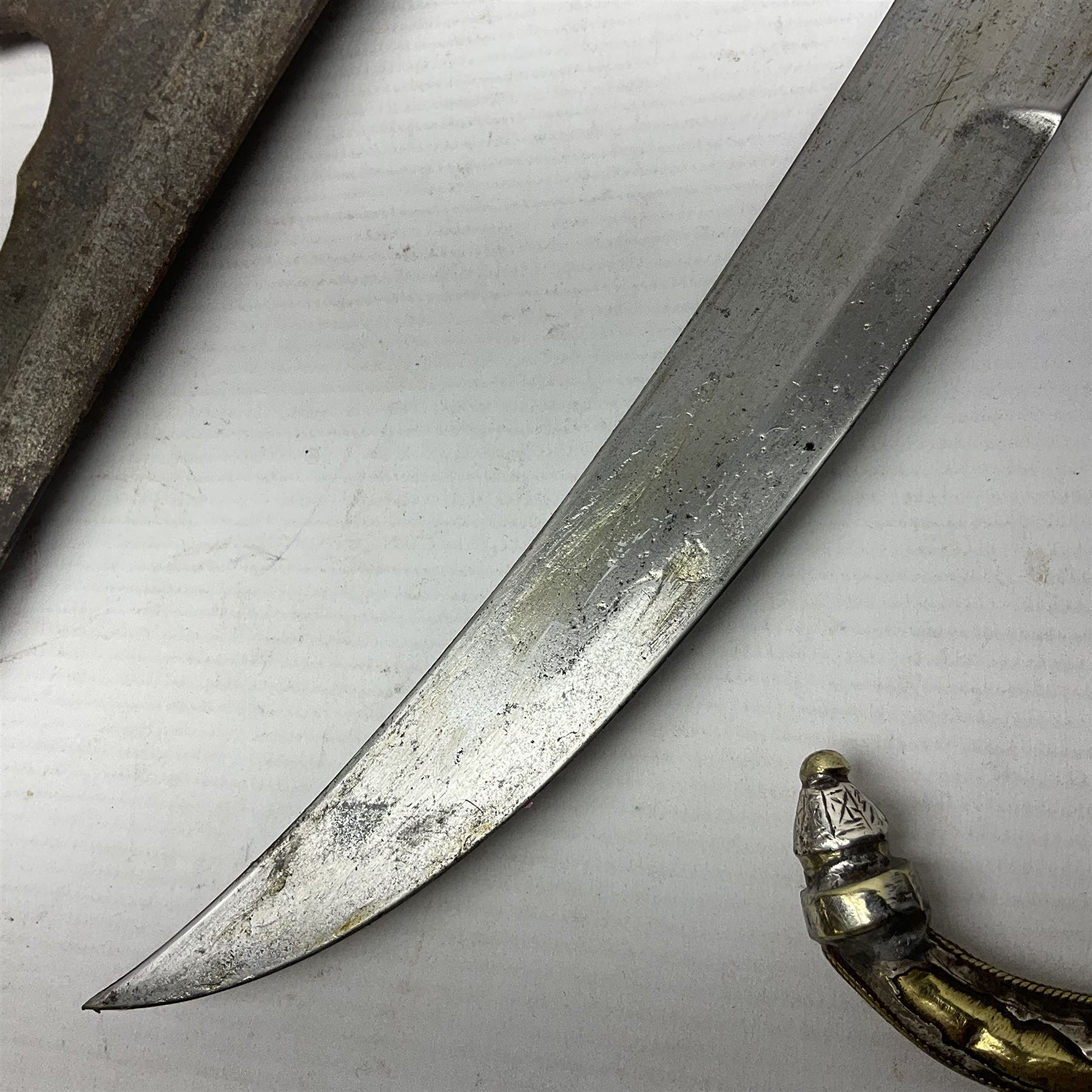 Moroccan jambiya dagger with 24.5cm plain curved blade stamped LONDON to the ricasso area, the hilt and scabbard overlaid with plain sheet brass to the back and ornate silver coloured metal to the front; waisted grip and arched pommel; two pyramid mounts to the scabbard L41cm overall; large billhook with curving blade and stacked leather washer grip; and a reproduction halberd blade (3)