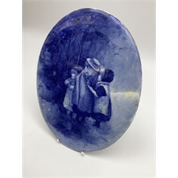 A Royal Doulton blue and white wall plaque, of oval form decorated with children, H25.5cm W19.5cm.