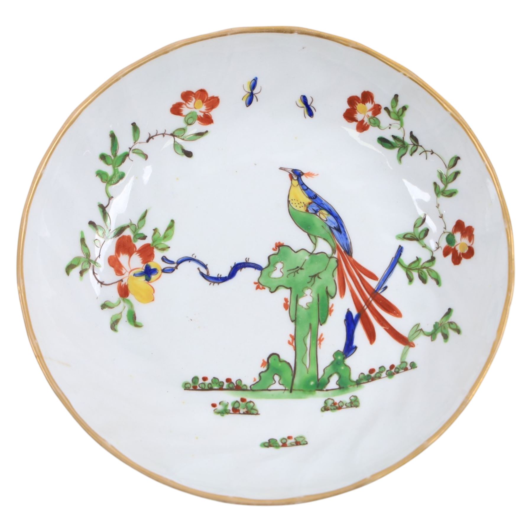 Chamberlain's Worcester teabowl and saucer, each of wrythen form decorated in the Sir Joshua Reynolds pattern, circa 1800, with long tailed Ho Ho bird perched upon green rockwork and surrounded by flowering vines, the saucer with iron red pattern number 203 beneath, teabowl H6cm D8.5cm, saucer D14cm