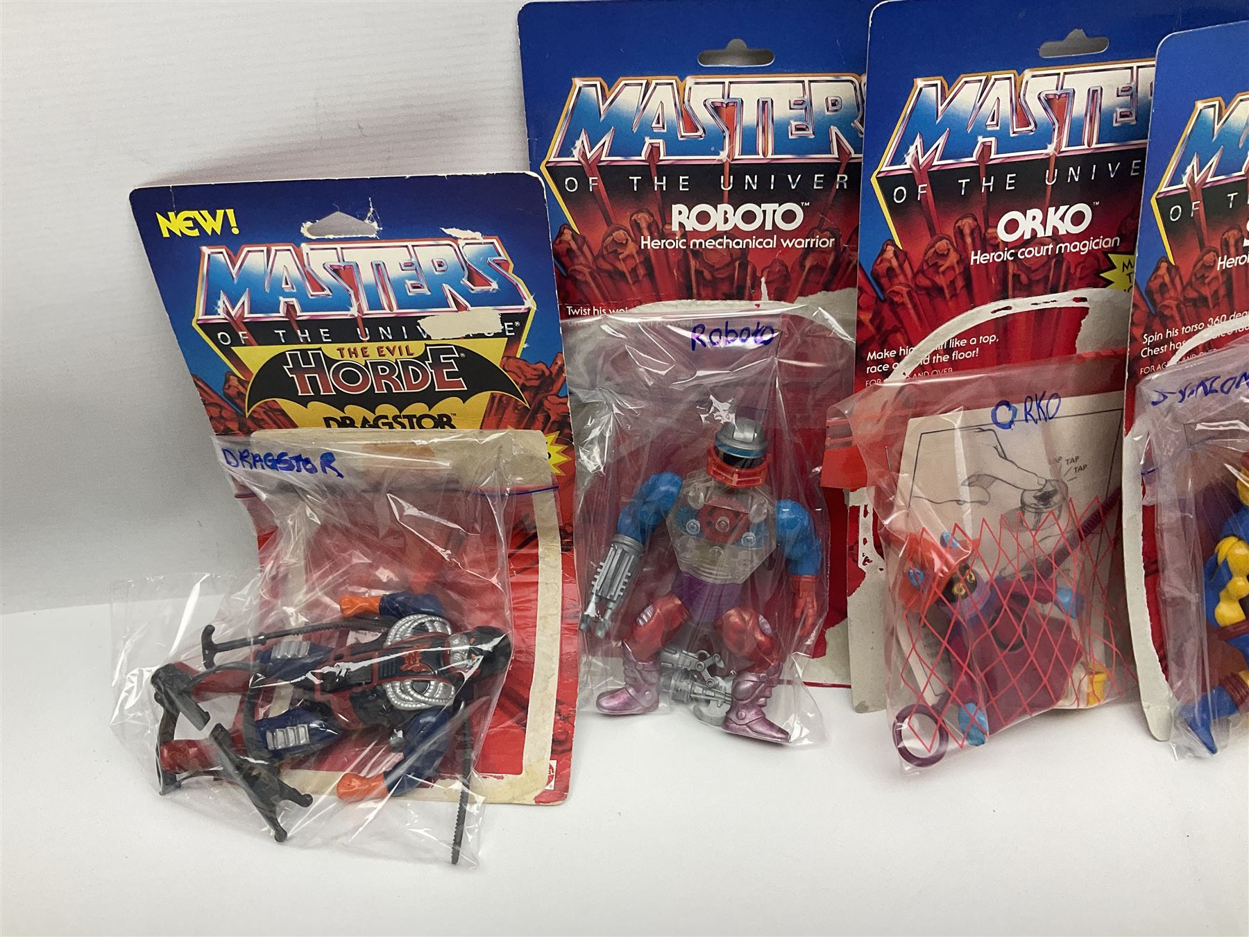 Thirty-one Masters of the Universe He-Man figures re-bagged on original backing cards;  two others lacking backing cards; boxed Modulok figure; bag of weapons and accessories; Roton, two horses and two battle cats; 1986 & 1987 Annuals; Ladybird and other story books; Panini sticker album; instructions etc