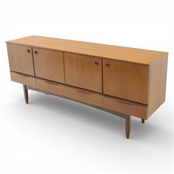 Portwood - Mid 20th century teak sideboard, rectangular top with fall front in the centre flanked by cupboard doors with recessed handles, above four drawers raised on tapered legs