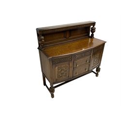 Early 20th century oak sideboard, the raised panelled back supports by two turned and carved balusters, shaped front with moulded top, fitted with three drawers and two cupboards, decorated with blind fretwork strapping, turned and carved baluster feet connected by moulded stretchers