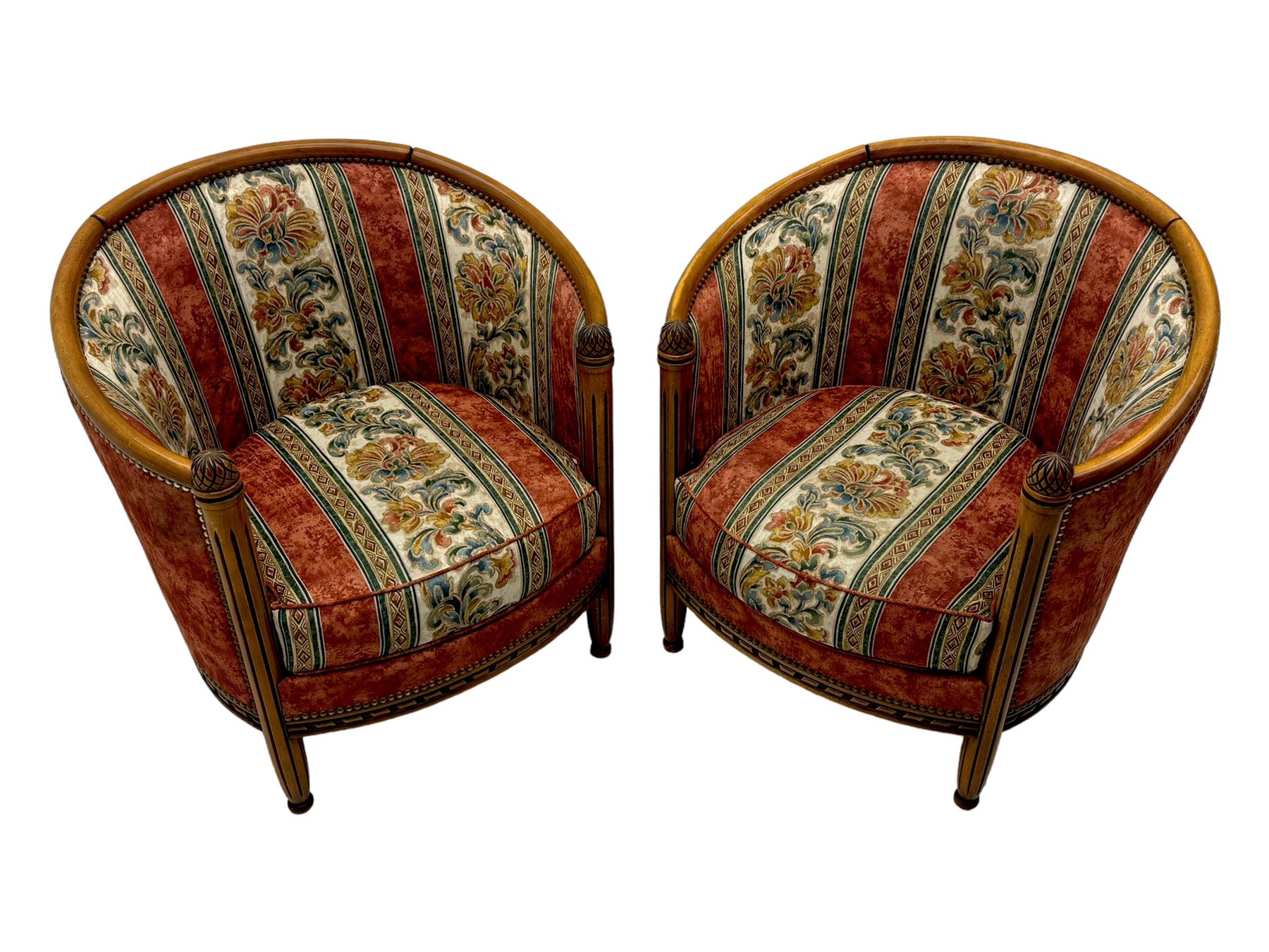 Pair of cherry wood framed tub-shaped armchairs, upholstered in striped floral fabric with brass stud trim, carved walnut frame with fluted supports capped with pinecone finials, on turned feet