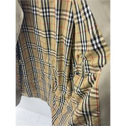 Ladies Burberry double breasted trench coat, with belt and detachable woollen gilet, in traditional cream colour with Burberry check lining, together with a gentlemans Burberry single breasted trench coat, both L112cm