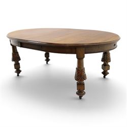 Late 19th century French oak extending dining table, oval top with moulded edge and plain frieze, raised on four ornate carved supports decorate with carved latticework and large festoons with tassels, on turned feet, with two additional leaves
