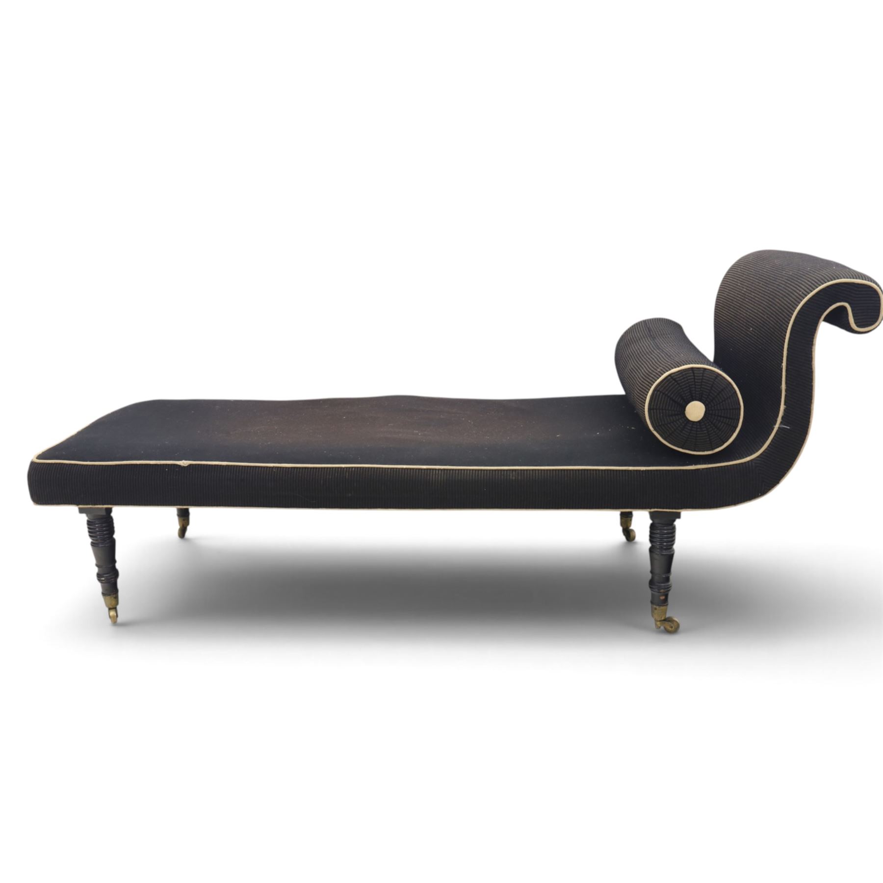 Victorian ebonised chaise longue, upholstered in black fabric with scroll headrest and bolster cushion, rectangular seat with rounded corners, raised on turned supports terminating in brass and ceramic castors
