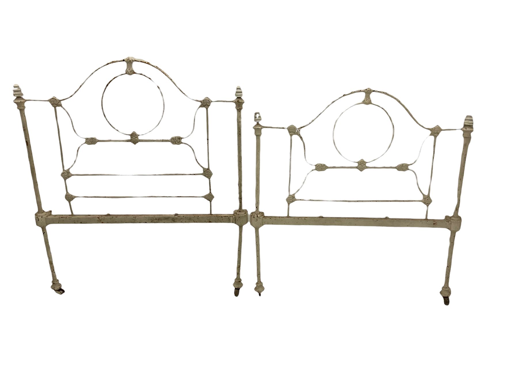 Two stripped walnut barley twist headboards, and a pair of wrought metal single bed ends