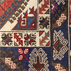 Caucasian Shirvan hand-knotted rug, red madder field with hooked lozenge medallions and stylized motifs, framed by ivory stepped spandrels and multiple geometric borders in indigo brown and ivory, with serrated palmettes and angular devices 