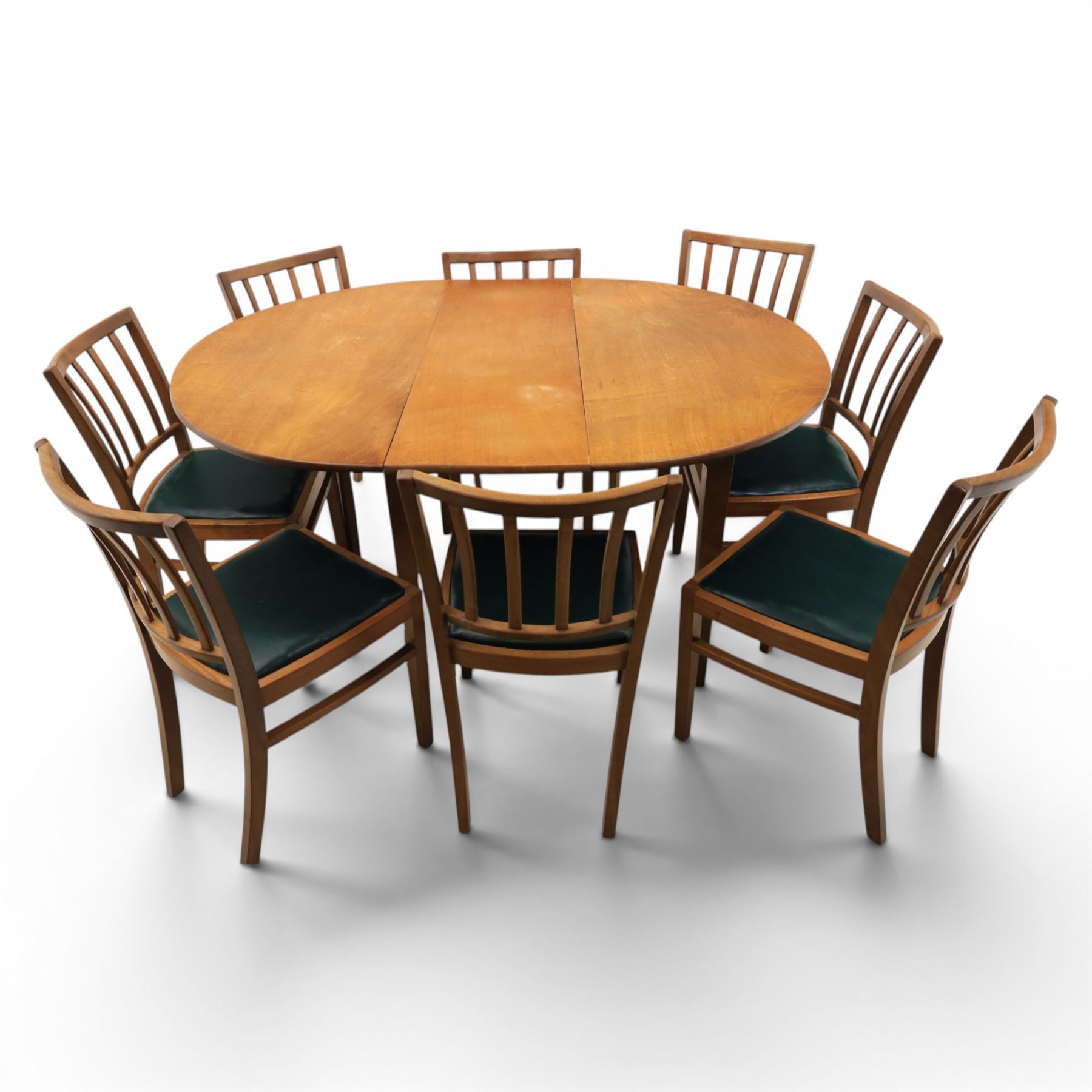Mid 20th century teak extending dining table, together with eight teak chairs with green leather seats, extends to 154cm