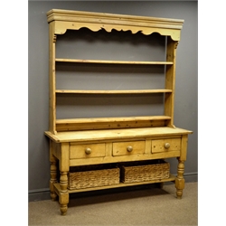  Traditional pine dresser, projecting cornice, shaped frieze, three tier plate rack above three drawers, turned supports joined by an undertier with wicker baskets, W142cm, H191cm, H47cm  