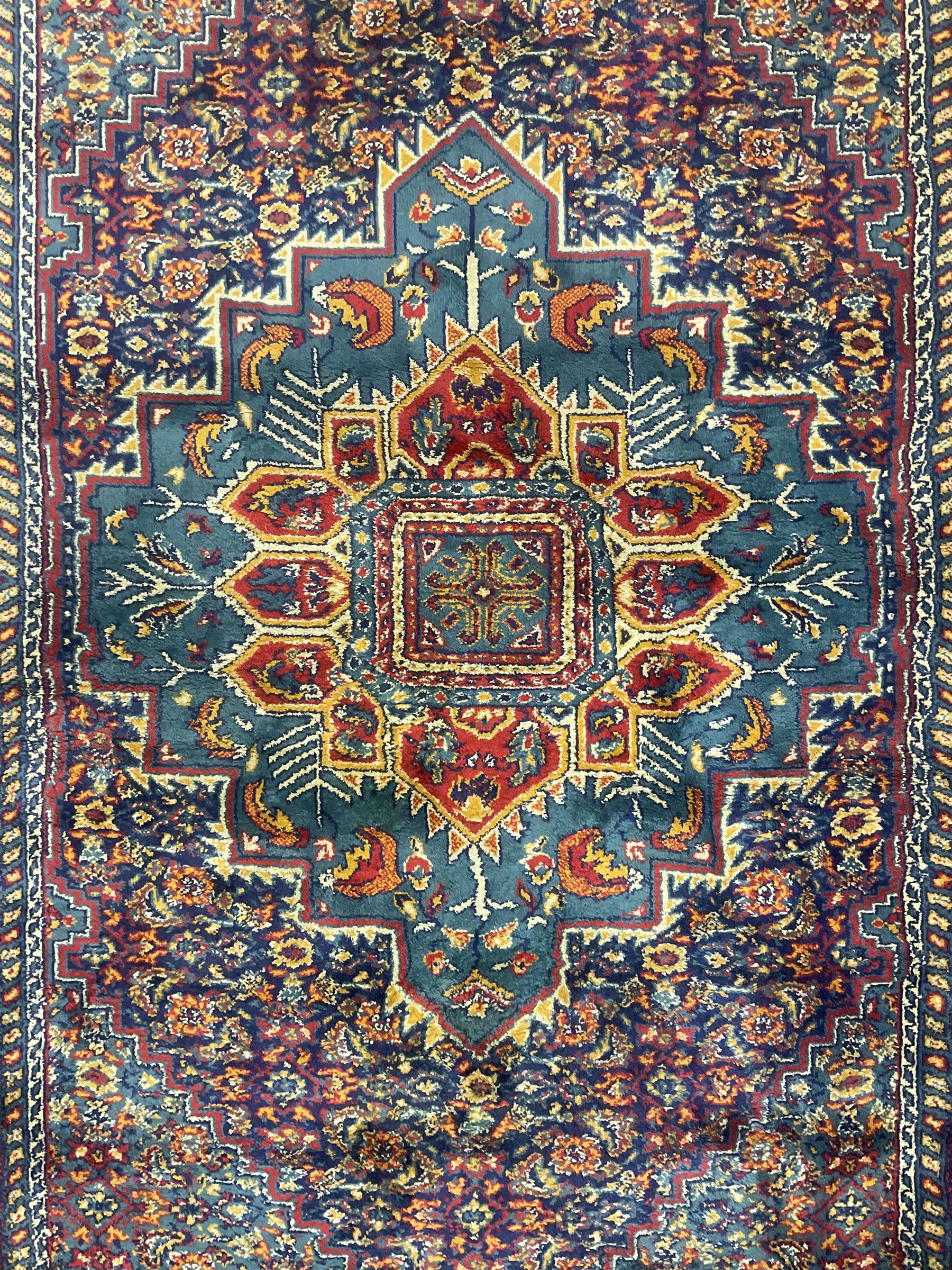 Persian design blue ground rug, the field decorated with Herati motifs and central floral medallion, repeating guarded border decorate with flower heads and trailing leafy branches 